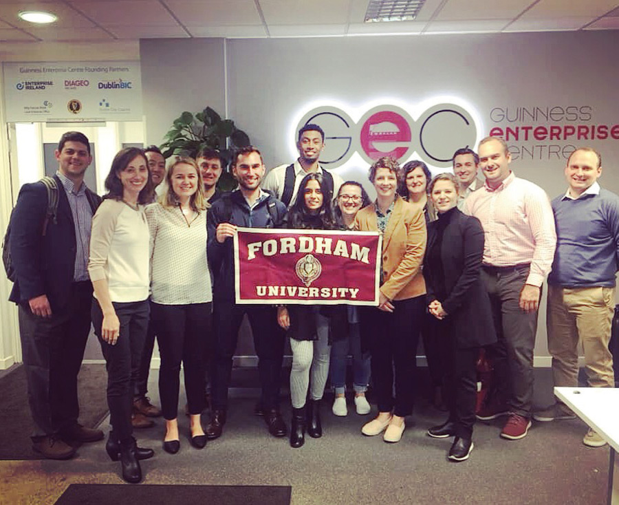 A group of professional MBA students holding Fordham University banner