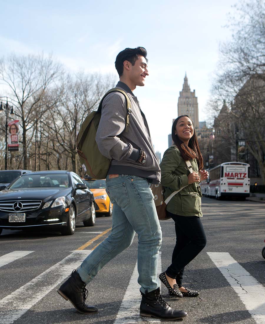 students walking on a cross walk and smiling
