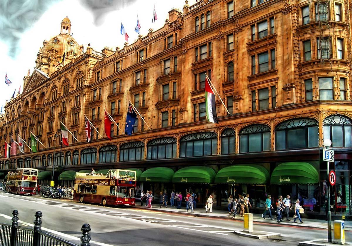 Fordham Gabelli School of Business master’s students visited several companies in London, including Harrods, where they learned about the luxury department store’s sustainable business model as the street is seen filled with so many people walking on the sidewalk and double decker buses nearby on the road.