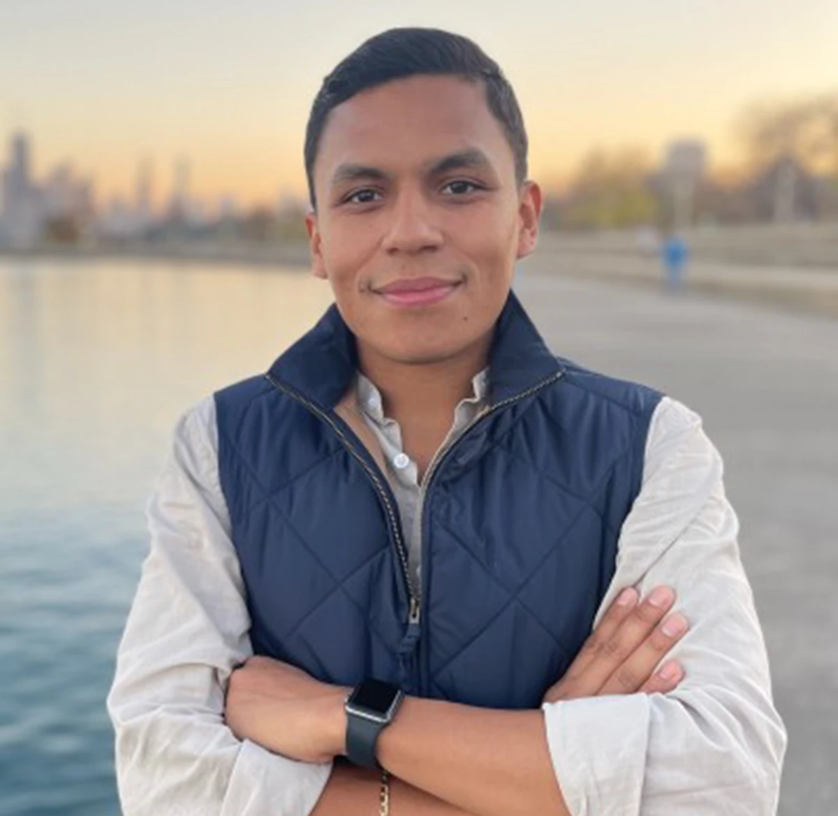 Fernando Montejo standing with his arms crossed in front of a beach
